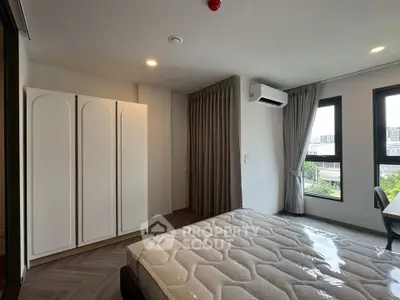 Modern bedroom with large windows and stylish wardrobe in a high-rise apartment.