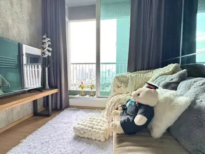 Cozy living room with plush decor and city view balcony