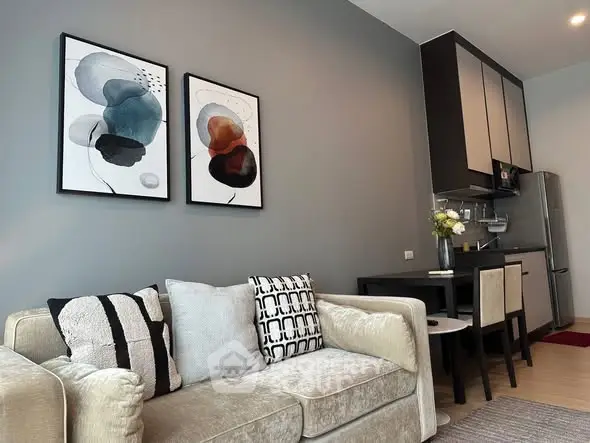 Modern living room with stylish decor and compact kitchen in open layout apartment.