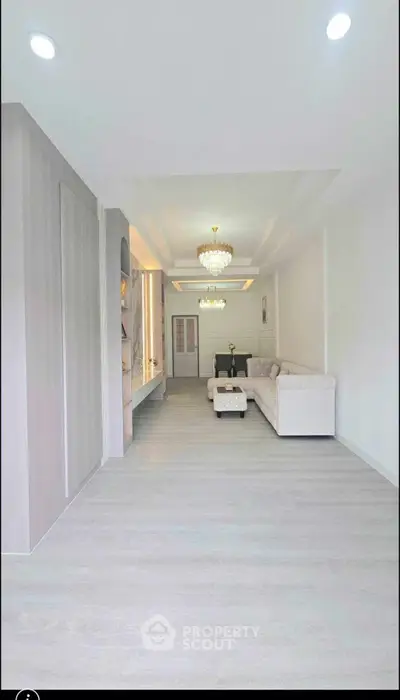 Spacious modern living room with elegant chandelier and white sofa