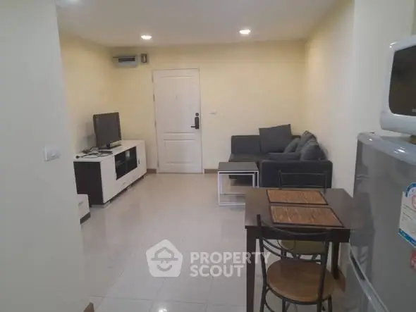 Cozy living room with modern furniture and dining area in a compact apartment.