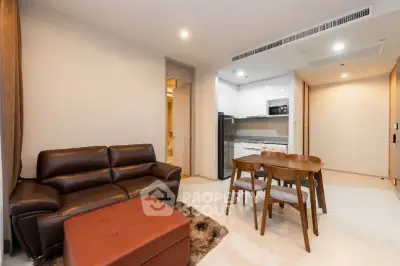Modern living room with leather sofa and dining area in open layout apartment.