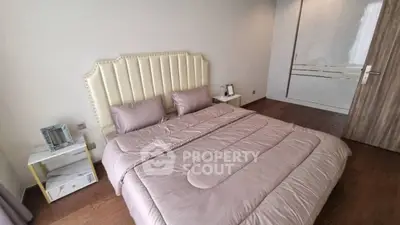 Cozy bedroom with elegant headboard and soft bedding in modern apartment.