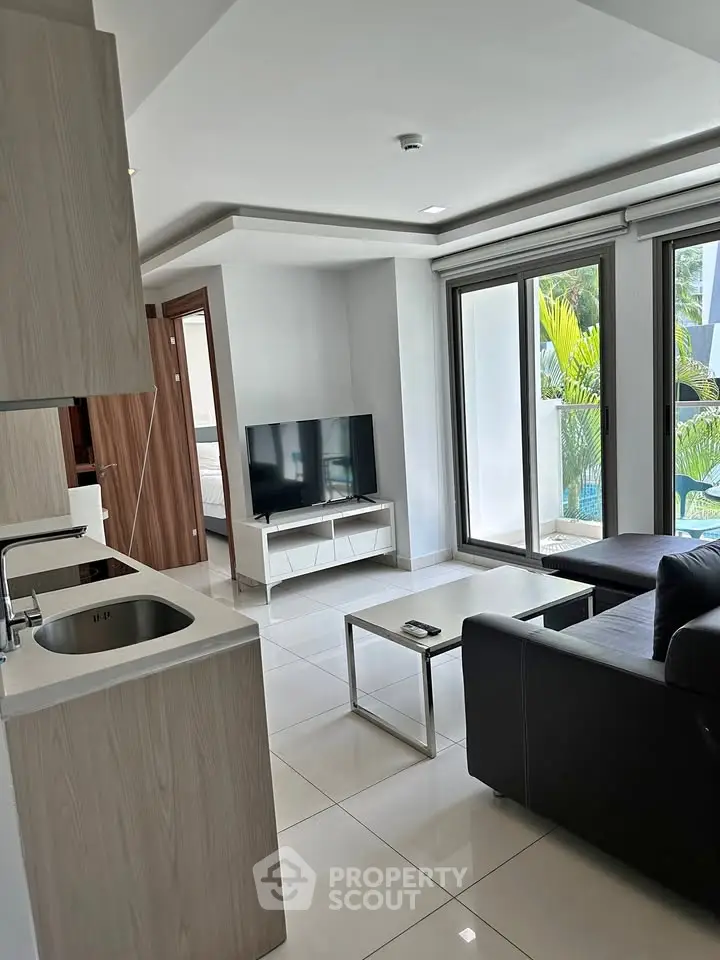 Modern living room with sleek design and pool view, featuring a cozy seating area and large windows.