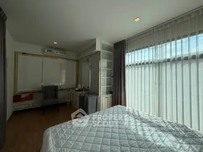 Spacious bedroom with large windows and elegant decor