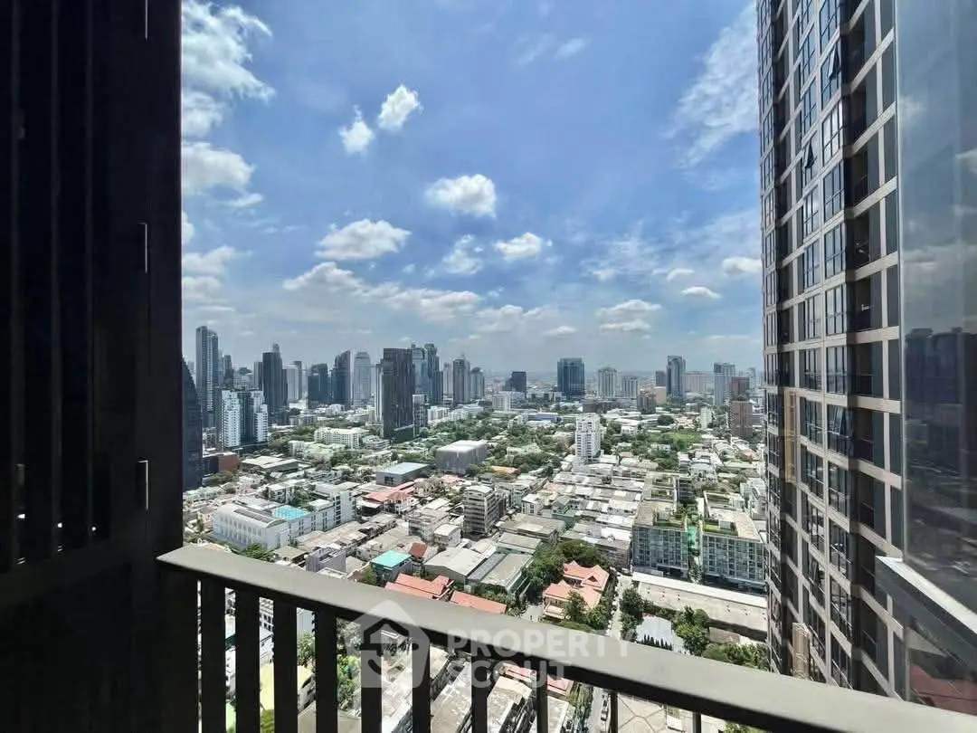 Stunning cityscape view from high-rise balcony with clear blue sky.