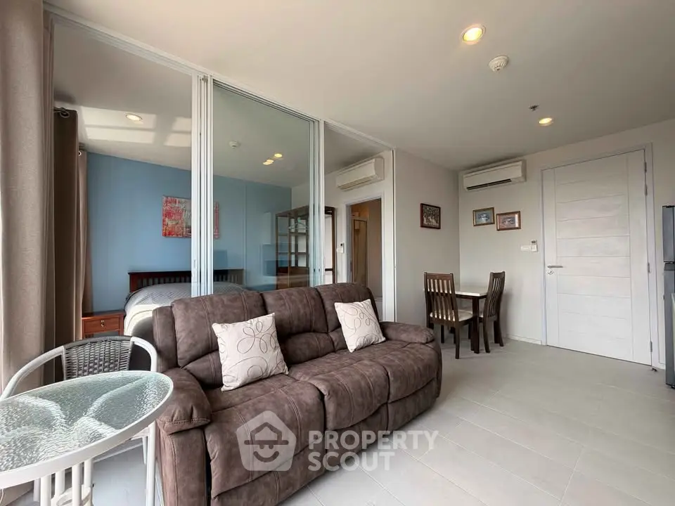 Modern living room with cozy sofa and dining area in open-plan apartment