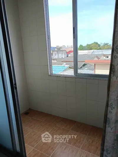 Cozy balcony with tiled flooring and city view, perfect for relaxation and enjoying the outdoors.