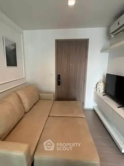 Cozy living room with beige sofa and modern entertainment setup