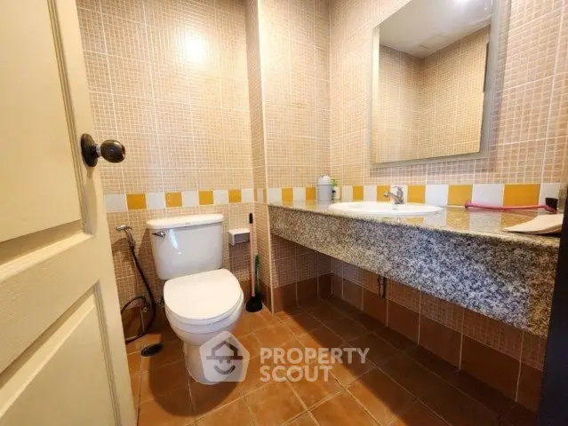 Modern bathroom with granite countertop and tiled walls in a cozy real estate property.