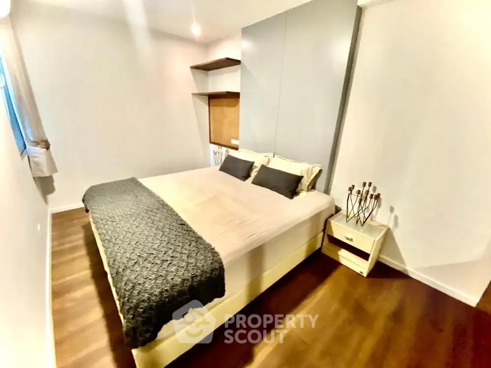 Cozy modern bedroom with stylish decor and wooden flooring