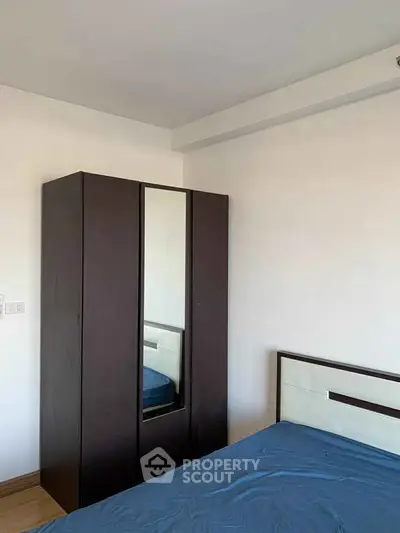 Cozy bedroom with modern wardrobe and stylish bed frame, perfect for urban living.