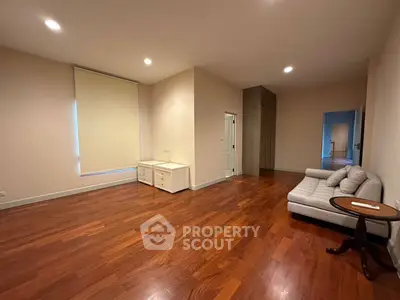 Spacious living room with hardwood floors and cozy sofa, perfect for relaxation.