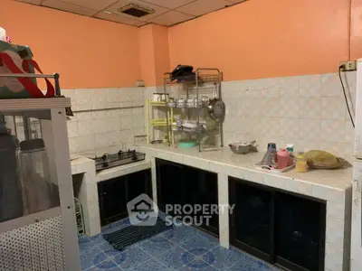 Cozy kitchen with gas stove and ample storage space, featuring tiled walls and floor for easy maintenance.