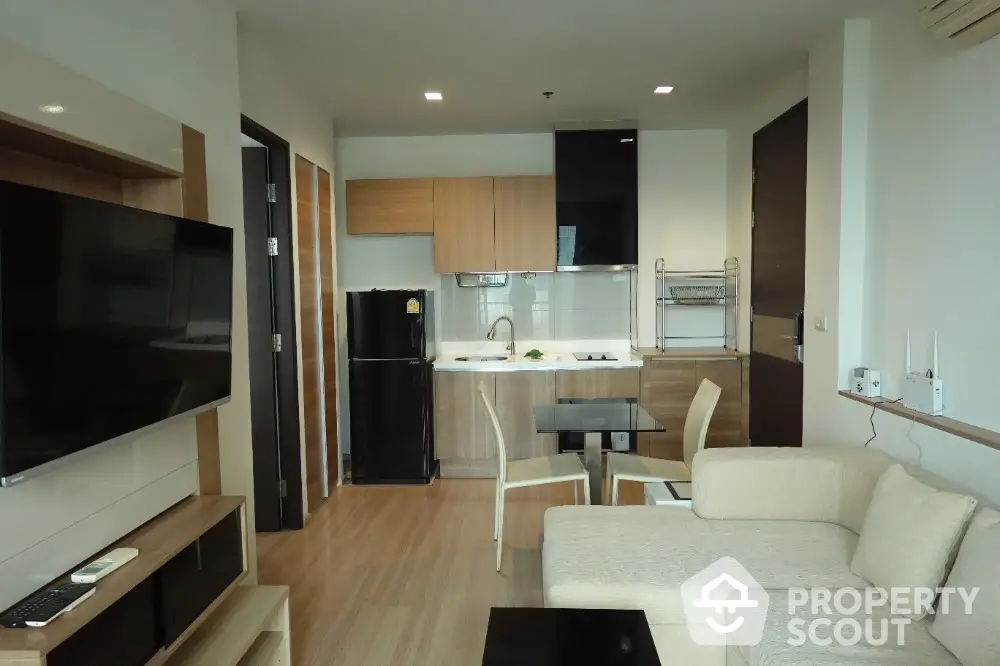 Modern open-plan living room with kitchen, featuring sleek furniture and contemporary design.