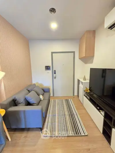Modern living room with stylish decor and large TV, perfect for relaxation and entertainment.