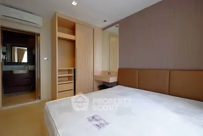 Modern bedroom with ensuite bathroom and built-in wardrobe in a stylish apartment.