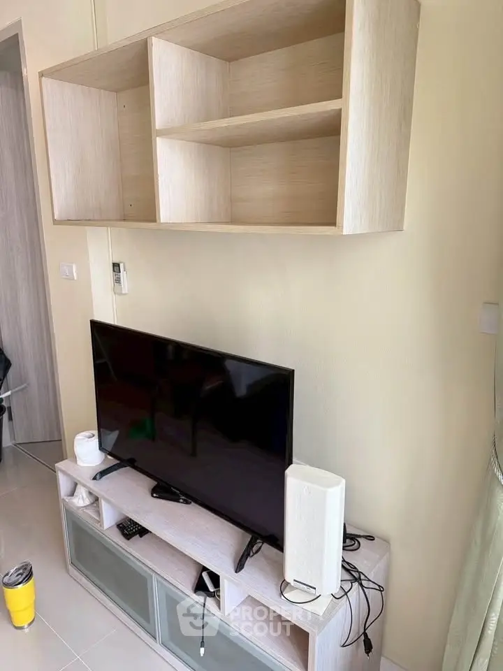 Modern living room with sleek TV stand and wall-mounted shelves, perfect for stylish urban living.