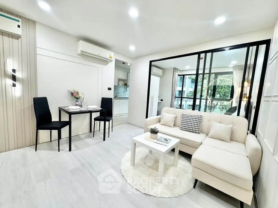 Modern living room with elegant decor and open layout, featuring a cozy dining area and large windows.