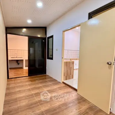 Spacious interior with modern wooden flooring and open kitchen layout, perfect for contemporary living.