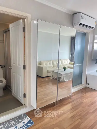 Modern apartment interior with mirrored wardrobe and cozy living area