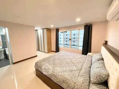 Spacious modern bedroom with large windows and elegant decor