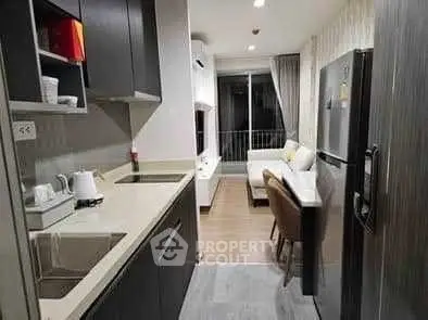 Modern kitchen with sleek cabinets and open layout leading to cozy living area.