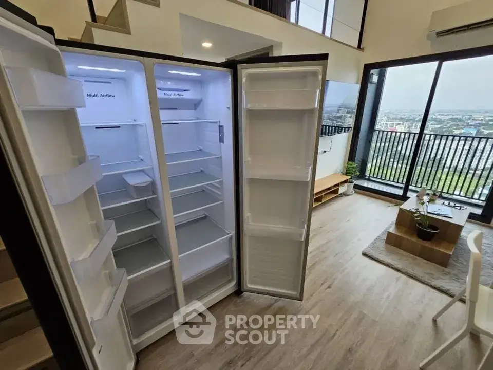 Spacious modern living room with open kitchen and large balcony view