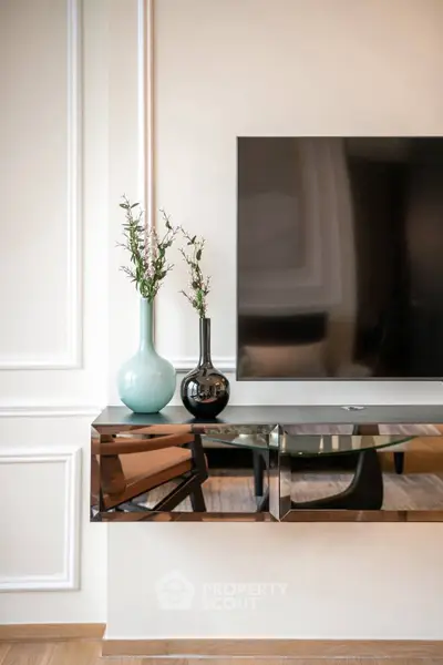 Elegant modern living room with sleek TV stand and decorative vases, showcasing contemporary interior design.