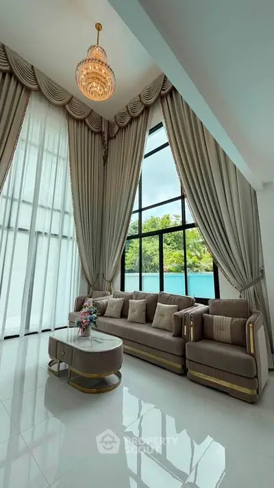 Luxurious living room with high ceilings, elegant drapes, and modern furniture.