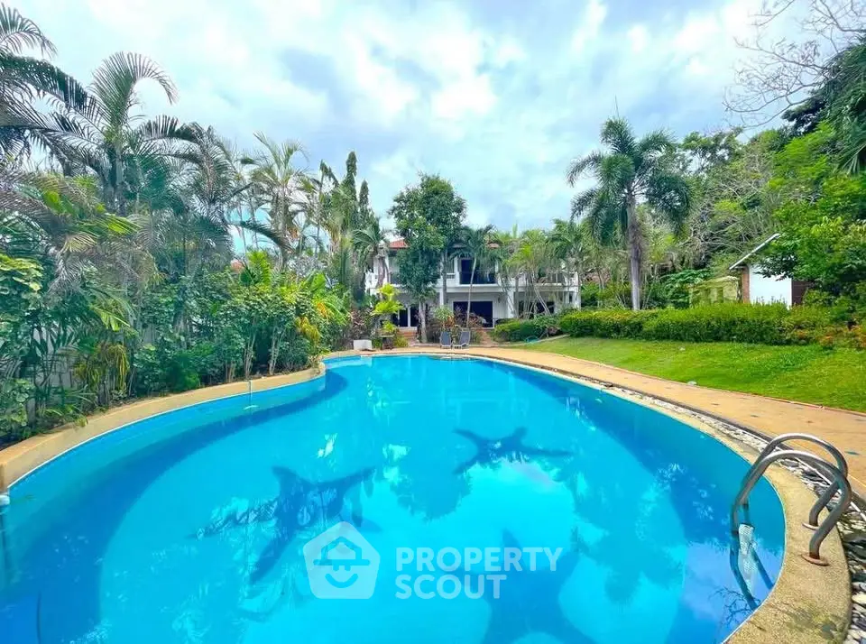Stunning tropical pool surrounded by lush greenery and elegant architecture.