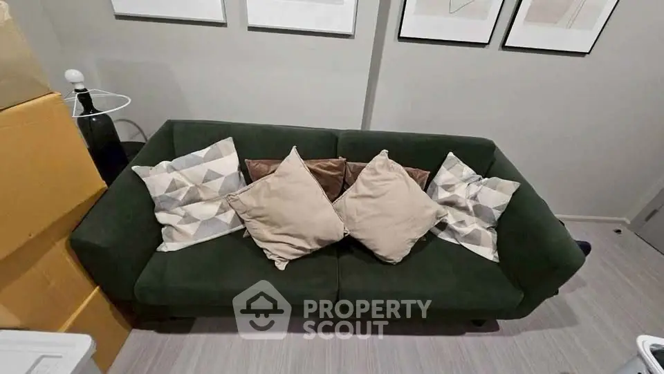 Stylish living room with modern green sofa and decorative pillows, perfect for cozy relaxation.