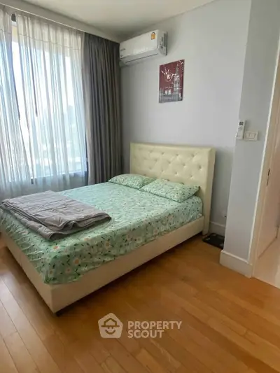 Cozy bedroom with natural light and modern decor in a stylish apartment.