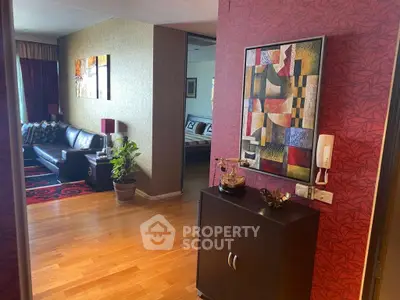 Stylish living room with modern decor and vibrant artwork, featuring hardwood floors and cozy seating area.