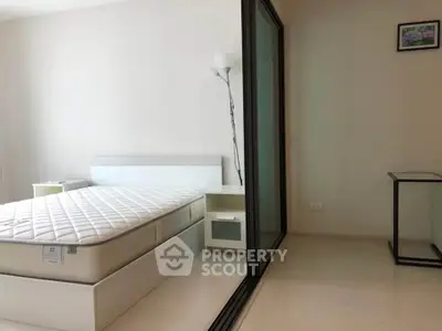 Modern minimalist bedroom with glass partition and sleek furniture design.