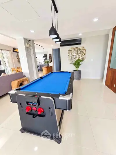 Spacious living room with pool table and modern decor in a stylish home.
