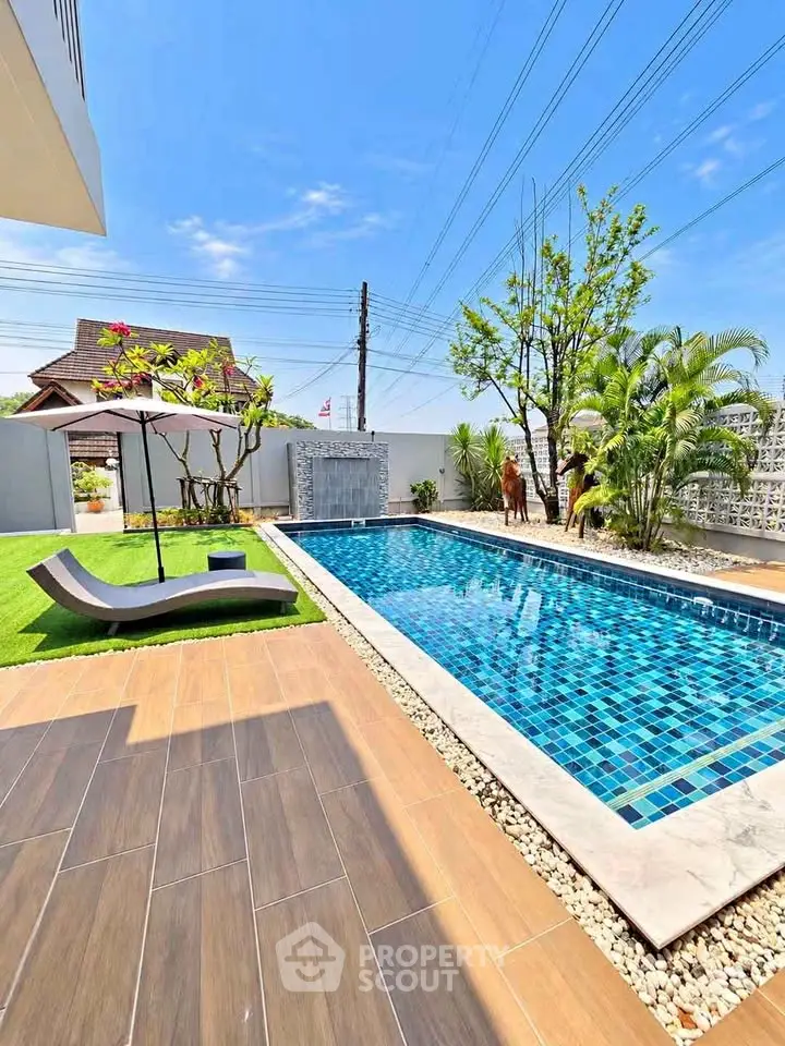 Luxurious outdoor pool area with modern design and lush greenery, perfect for relaxation and entertainment.