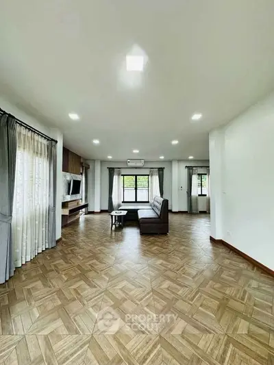 Spacious living room with modern decor and large windows for natural light.