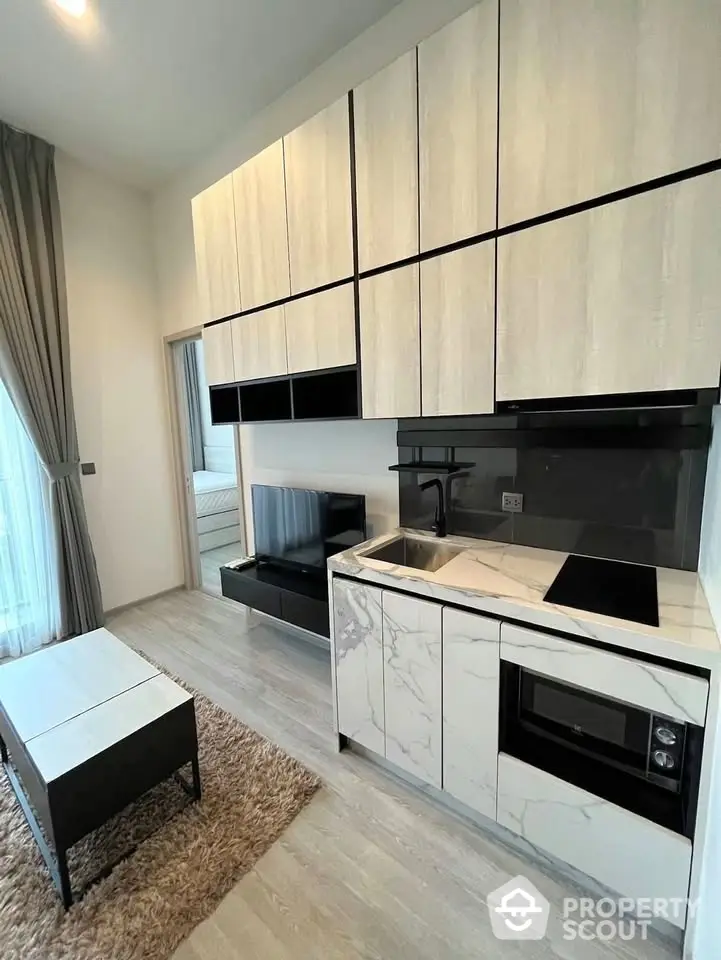 Modern compact kitchen with sleek cabinetry and integrated appliances in a stylish apartment