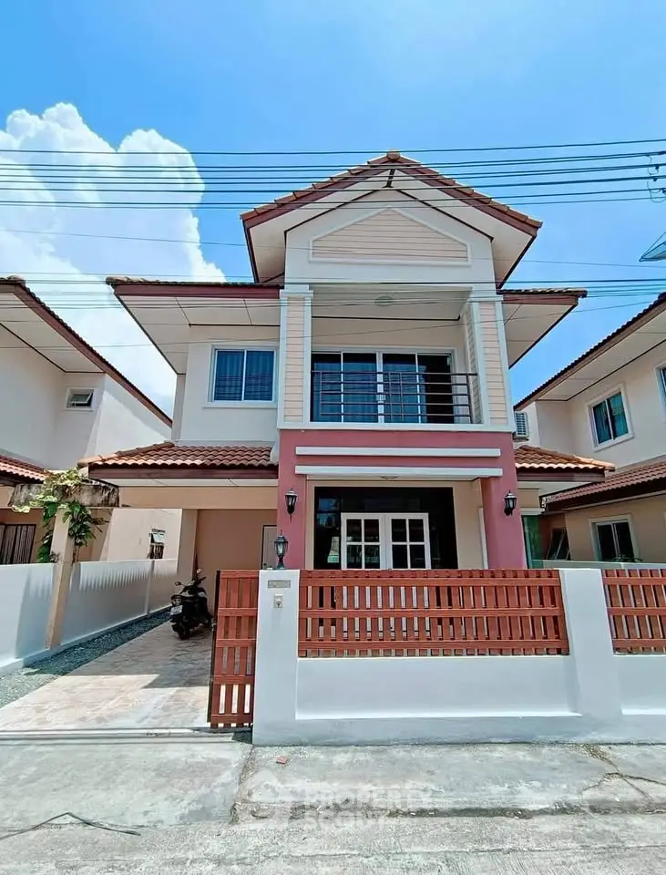 Charming two-story house with red accents and spacious front yard in a serene neighborhood.