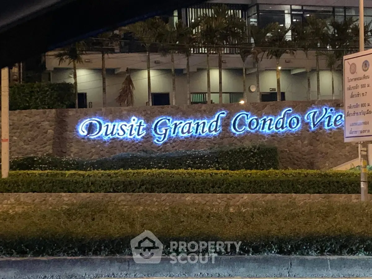 Dusit Grand Condo View entrance with illuminated signage and lush landscaping.