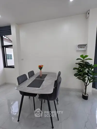 Modern dining area with sleek table and chairs, bright natural light, and elegant decor.