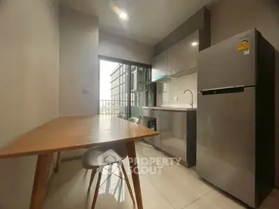 Modern kitchen with sleek cabinetry and dining area in a stylish apartment.