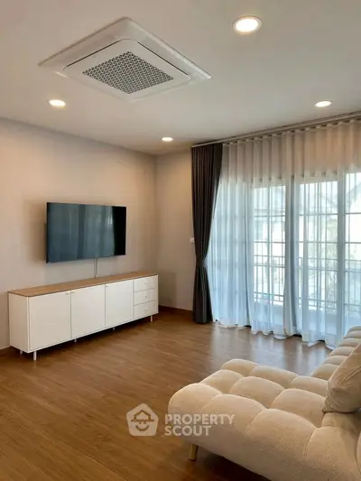 Modern living room with sleek TV setup and elegant curtains