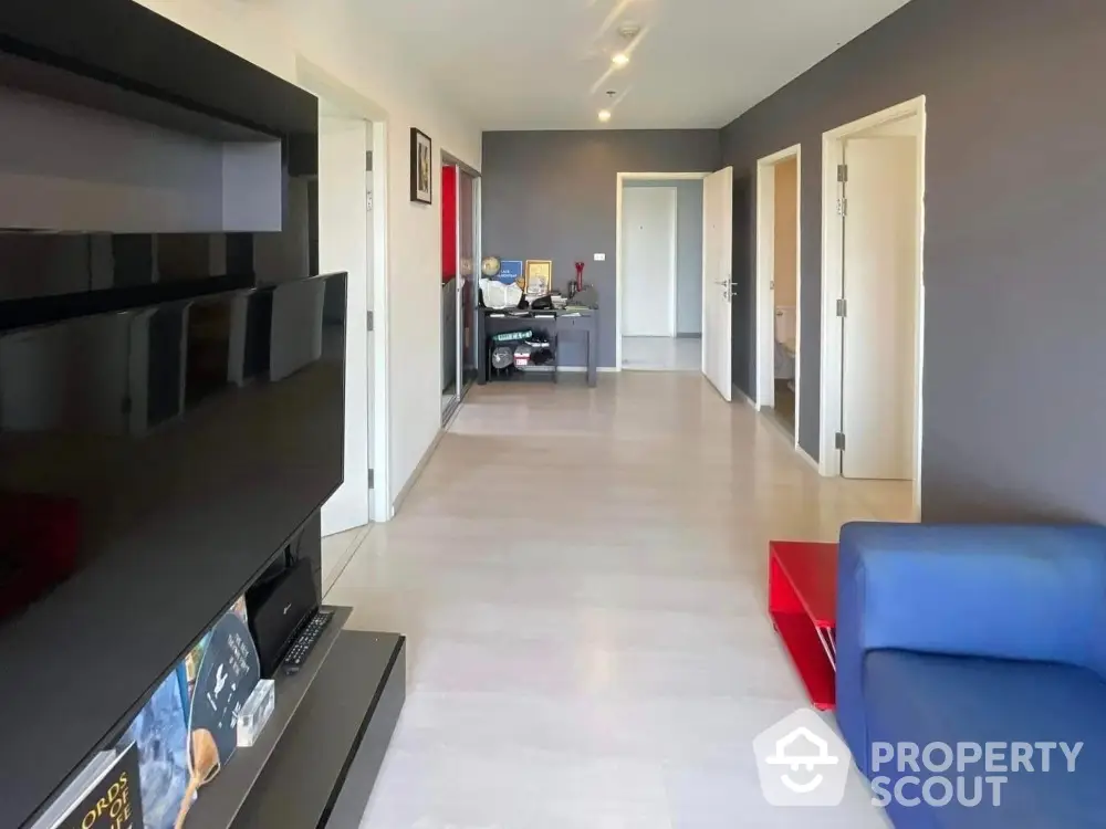 Modern living room with sleek black entertainment unit and vibrant blue sofa