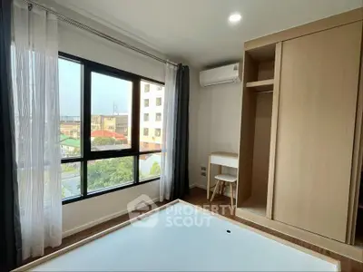 Bright bedroom with large window and built-in wardrobe in modern apartment
