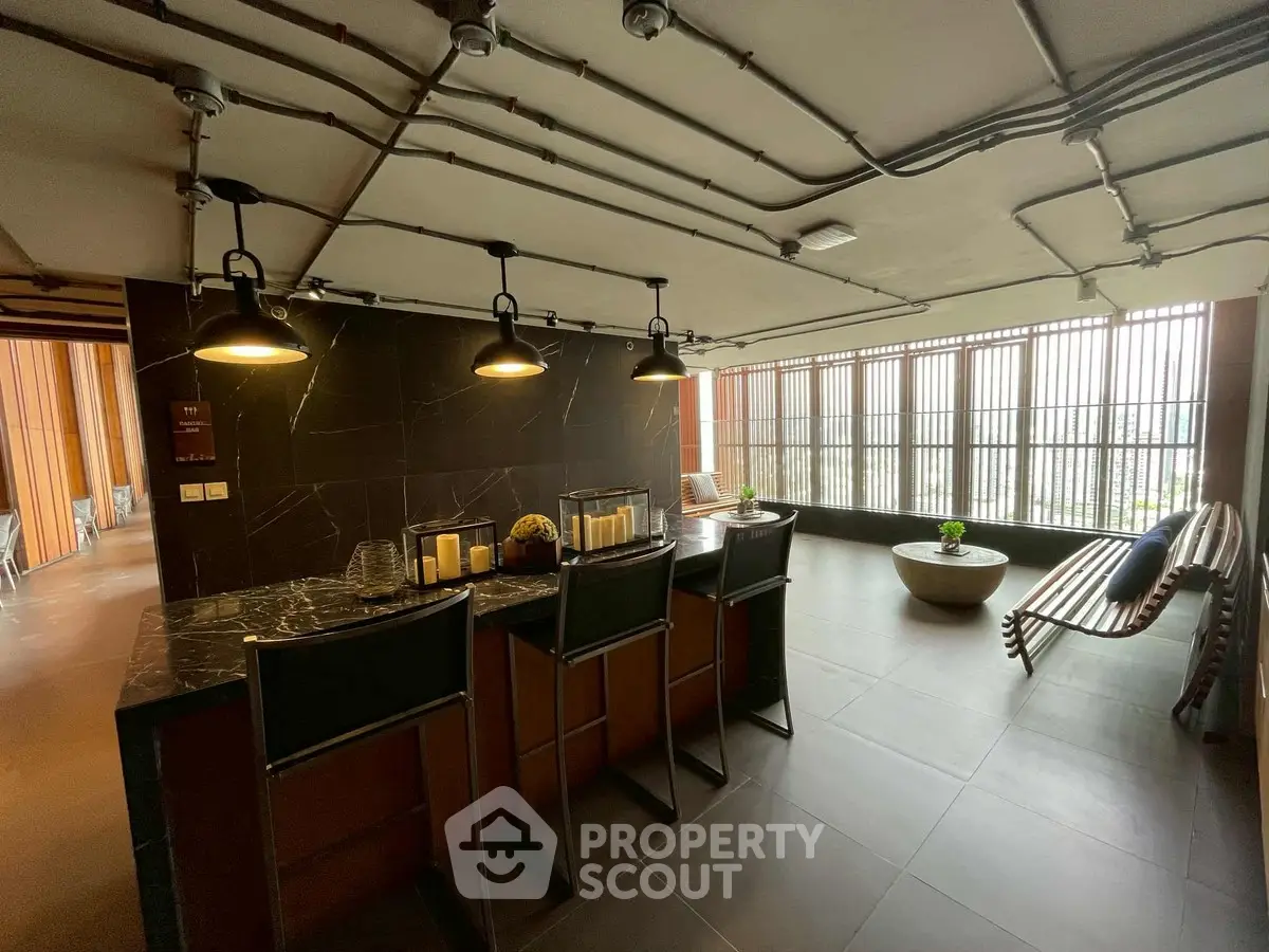 Stylish modern interior with sleek bar area and floor-to-ceiling windows in a luxury apartment building.