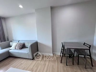Modern living room with sleek sofa and dining table, featuring minimalist design and cozy ambiance.