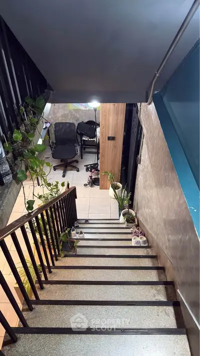 Modern staircase with indoor plants leading to a cozy home office space