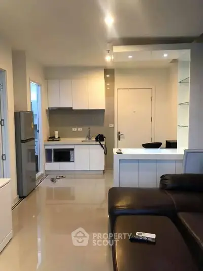 Modern open-layout kitchen with sleek appliances and cozy living area, perfect for urban living.